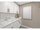 Bright laundry room with white cabinets and hexagon tile floor at 5760 Tillman Way, Powder Springs, GA 30127