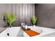Soaking tub with wooden tray and decorative plants at 1958 Dillon Dr, Lithonia, GA 30058
