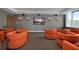Comfortable theater room with orange chairs and a large screen TV at 860 Peachtree Ne St # 1903, Atlanta, GA 30308