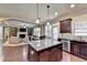 Kitchen with granite island, stainless steel appliances, and view into Gathering room at 3191 Lake Mcginnis Dr, Suwanee, GA 30024