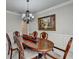 Elegant dining room featuring a wood table, chandelier, and wall art at 3191 Lake Mcginnis Dr, Suwanee, GA 30024