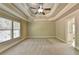 Spacious bedroom with carpeted floor, ceiling fan, and multiple windows at 3191 Lake Mcginnis Dr, Suwanee, GA 30024