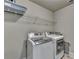 Bright laundry room with washer, dryer, and ample shelving at 3191 Lake Mcginnis Dr, Suwanee, GA 30024