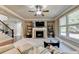 Living room featuring a fireplace, large windows, and comfortable seating at 3191 Lake Mcginnis Dr, Suwanee, GA 30024