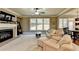Spacious living room with a fireplace, leather sofas, and a ceiling fan at 3191 Lake Mcginnis Dr, Suwanee, GA 30024