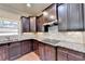 Kitchen with granite countertops and dark wood cabinets at 3191 Lake Mcginnis Dr, Suwanee, GA 30024