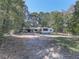 Charming white house nestled on a wooded lot with a gravel driveway at 198 Oak Hill Cir, Canton, GA 30114