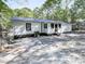 Rear view of a white house with a gravel driveway and trees at 198 Oak Hill Cir, Canton, GA 30114
