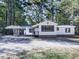 Charming white house with gray accents and a covered carport, nestled among lush greenery at 198 Oak Hill Cir, Canton, GA 30114