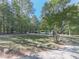 Landscaped yard with a gravel driveway and mature trees at 198 Oak Hill Cir, Canton, GA 30114