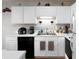 Bright kitchen boasts white cabinets, black appliances, and a double sink at 253 Gallant Se # 17, Mableton, GA 30126