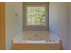 Bathroom with jetted tub and large window at 2404 Lake Cove Ct, Lithonia, GA 30058