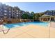 Community pool with surrounding lounge chairs and building in background at 2300 Peachford Rd # 1205, Dunwoody, GA 30338