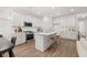 Open concept kitchen with white cabinets, island, and stainless steel appliances at 51 Airmont Dr, Sharpsburg, GA 30277
