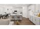 Modern kitchen with white cabinets, island with seating, and hardwood floors at 51 Airmont Dr, Sharpsburg, GA 30277