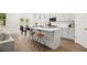 Modern kitchen with white cabinets, a large island, and hardwood floors at 51 Airmont Dr, Sharpsburg, GA 30277