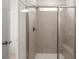 Spacious walk-in shower with neutral tile, glass doors, and built-in seat at 51 Airmont Dr, Sharpsburg, GA 30277