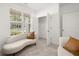 Bright sitting area with a curved sofa, open closet, and large window at 51 Airmont Dr, Sharpsburg, GA 30277