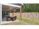 Covered patio with seating area and wooded view at 51 Airmont Dr, Sharpsburg, GA 30277