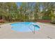 Inviting kidney-shaped pool surrounded by a brick wall and lush trees at 512 Clearwater Dr, Mcdonough, GA 30252