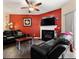 Living room featuring black leather furniture, a fireplace, and bold red accent wall at 780 Nehemiah Sw Ln, Atlanta, GA 30331