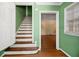 View of staircase leading upstairs, with green walls and hardwood floors at 2490 Cascade Sw Rd, Atlanta, GA 30311