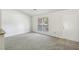 Living room with large windows, neutral carpet, and exterior door at 5035 Fairforest Dr, Stone Mountain, GA 30088