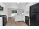 Modern kitchen with island, white cabinets, and black appliances at 124 Silver Fox Trl, Dallas, GA 30157