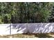 Private backyard with white vinyl fence and mature trees at 124 Silver Fox Trl, Dallas, GA 30157