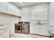 Spacious laundry room with white cabinets, quartz countertops, and modern appliances at 187 Fontaine Sw Rd, Mableton, GA 30126