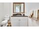 Elegant powder room with dark countertop, white vanity, and decorative mirror at 187 Fontaine Sw Rd, Mableton, GA 30126