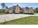 Large brick home with stone accents, a circular driveway, and manicured lawn at 187 Fontaine Sw Rd, Mableton, GA 30126