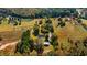 Aerial view of a house on a spacious lot with surrounding trees and fields at 4800 Pisgah Rd, Cumming, GA 30028