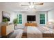 Virtually staged main bedroom with large windows and dresser at 2988 Woodrow Mnr, Lithonia, GA 30038
