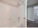 Simple bathroom with white tub and shower, and view to another room at 2459 Jacks View Ct, Snellville, GA 30078