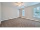 Spacious bedroom with neutral walls and carpet, ceiling fan, and two windows at 2459 Jacks View Ct, Snellville, GA 30078
