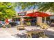 Oakhurst Market exterior with picnic tables and umbrellas creating a welcoming outdoor space at 108 Park Pl # 110, Decatur, GA 30030