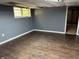 Unfinished basement room with gray walls, wood-look flooring, and window at 6883 Lakeshore Dr, Douglasville, GA 30135