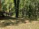 View of backyard with trees and grass at 6883 Lakeshore Dr, Douglasville, GA 30135