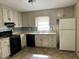 Shows the kitchen with white cabinets, black appliances, and tiled backsplash at 6883 Lakeshore Dr, Douglasville, GA 30135
