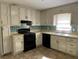 Another view of the kitchen, featuring white cabinets and black appliances at 6883 Lakeshore Dr, Douglasville, GA 30135