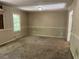 Another view of the living room with damaged walls and carpeting at 6883 Lakeshore Dr, Douglasville, GA 30135