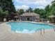 Community pool with a pool house, lounge chairs, and umbrellas at 4525 Twinberry Dr, Powder Springs, GA 30127