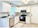 Updated kitchen with white cabinets, granite countertops, and stainless steel appliances at 430 Thornbush Trce, Lawrenceville, GA 30046