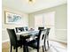 Bright dining room with large windows, a marble table, and six black leather chairs at 430 Thornbush Trce, Lawrenceville, GA 30046
