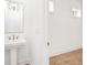 Modern powder room with pedestal sink and hardwood floors at 603 Brashy St, Woodstock, GA 30188