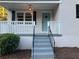 Inviting front porch with a light fixture, new railing, and a freshly painted door at 411 Greencove Se Ln, Atlanta, GA 30316