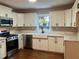 Updated kitchen featuring white cabinets, quartz countertops, stainless steel appliances, and hardwood floors at 411 Greencove Se Ln, Atlanta, GA 30316