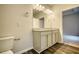 Double vanity bathroom with granite countertop, and grey plank flooring at 960 Park Place St, Social Circle, GA 30025