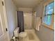 Full bathroom with tub and shower, and window with shutters at 220 Spalding Lake Pl, Atlanta, GA 30350